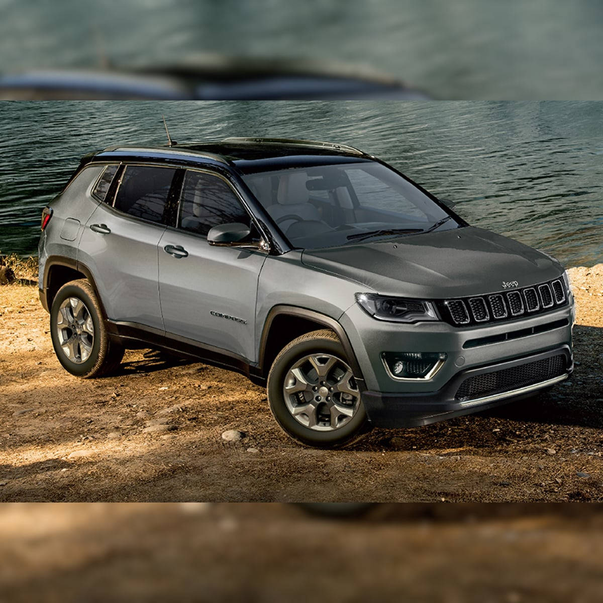 灰色Jeep Compass停泊在泥土岸邊近水處