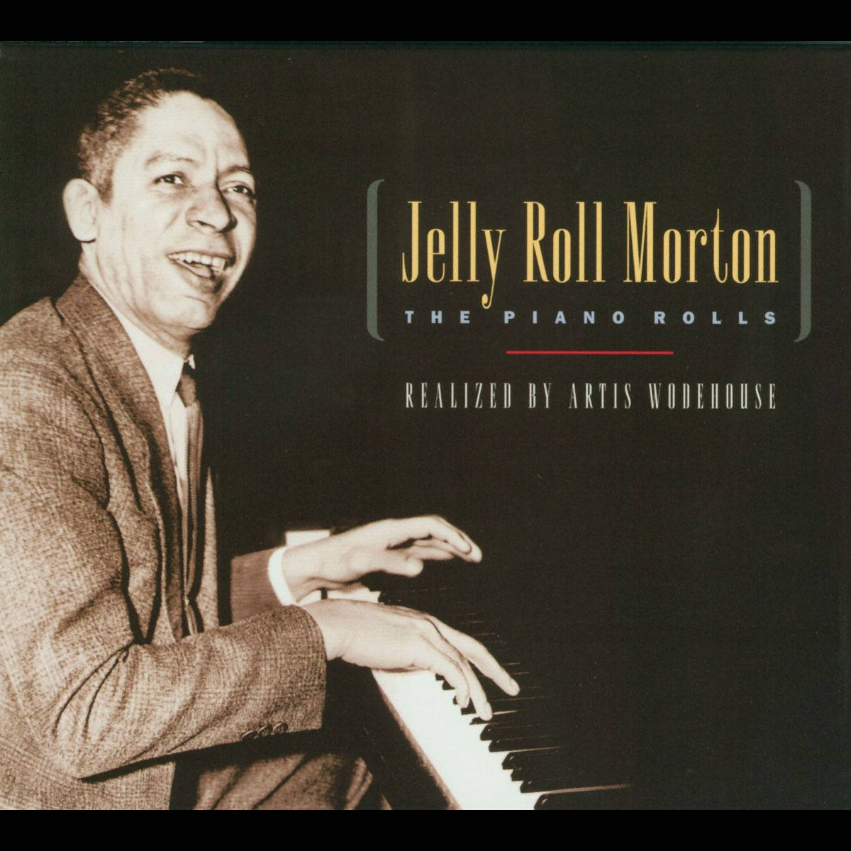 Jelly Roll Morton的鋼琴卷 壁紙 — Jelly Roll Morton 在復古棕褐色調肖像照中溫暖微笑彈奏鋼琴，並帶有文字疊加。