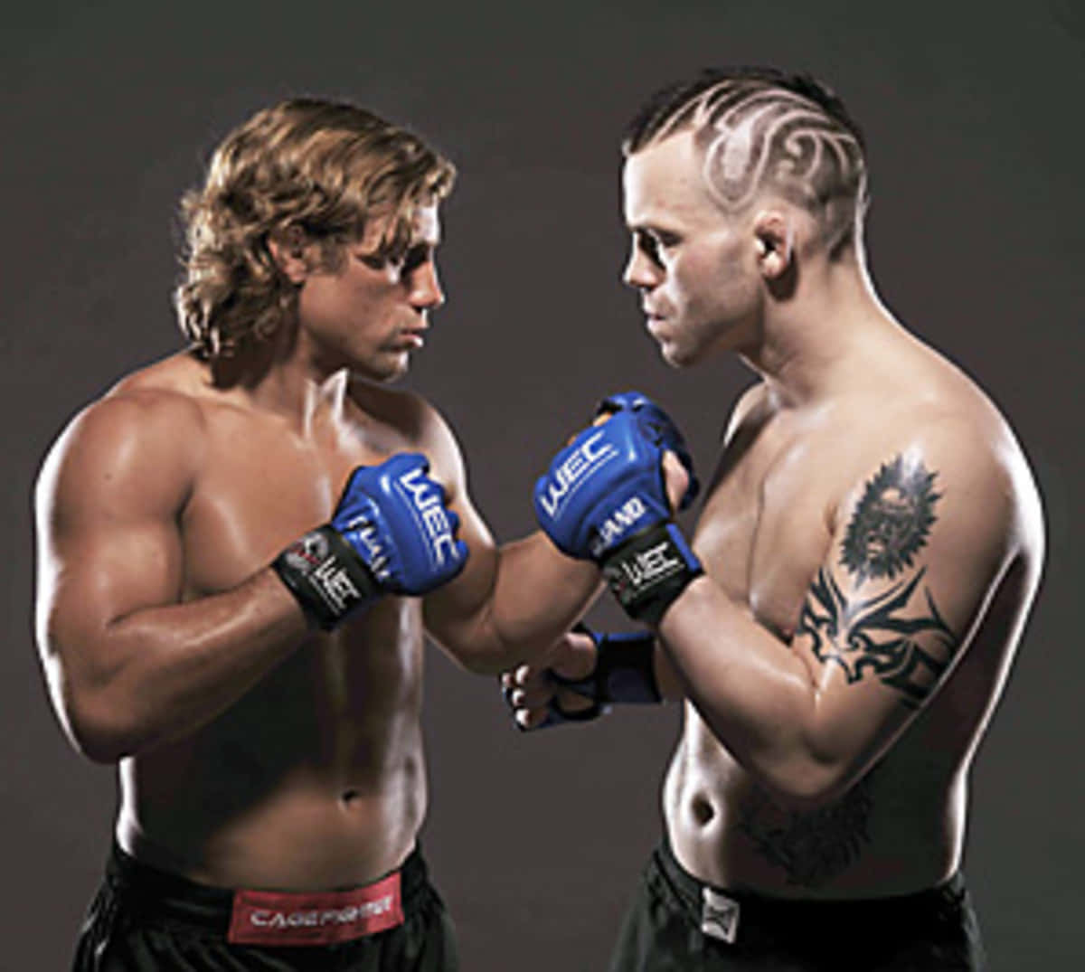 兩名赤裸上身的MMA拳手戴著藍色手套，以緊張的攝影棚姿勢對峙。