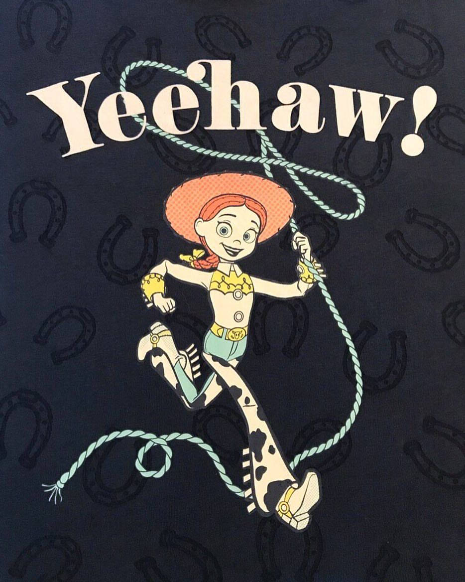 Jessie Toy Story Yeehaw海報 壁紙 — 一個紅髮卡通女牛仔拿著繩子在深藍色馬蹄鐵圖案背景上快樂地搖擺。