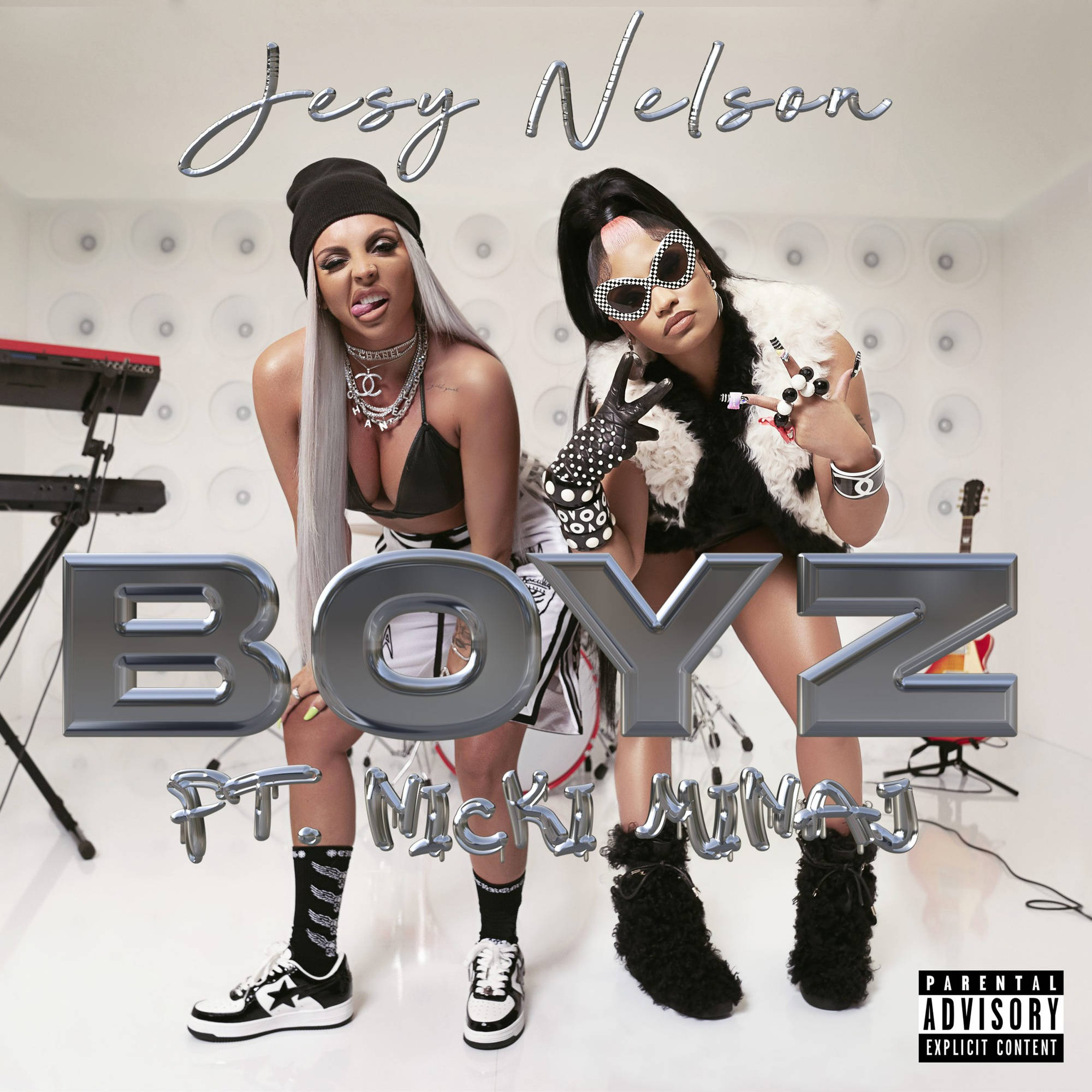 Jesy Nelson 與Nicki Minaj 壁紙 — 兩位身穿大膽黑白服裝的女性在簡約的工作室中自信地擺姿勢，周圍有樂器和金屬質感的專輯文字。