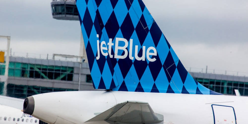 多雲天空下機場內的JetBlue飛機尾部