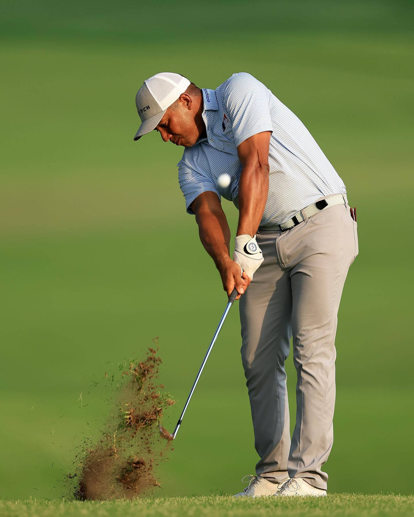 Jhonattan Vegas 成功擊球 壁紙 — 一名高爾夫球手揮動球桿，將球從翠綠球場的沙坑中擊出。