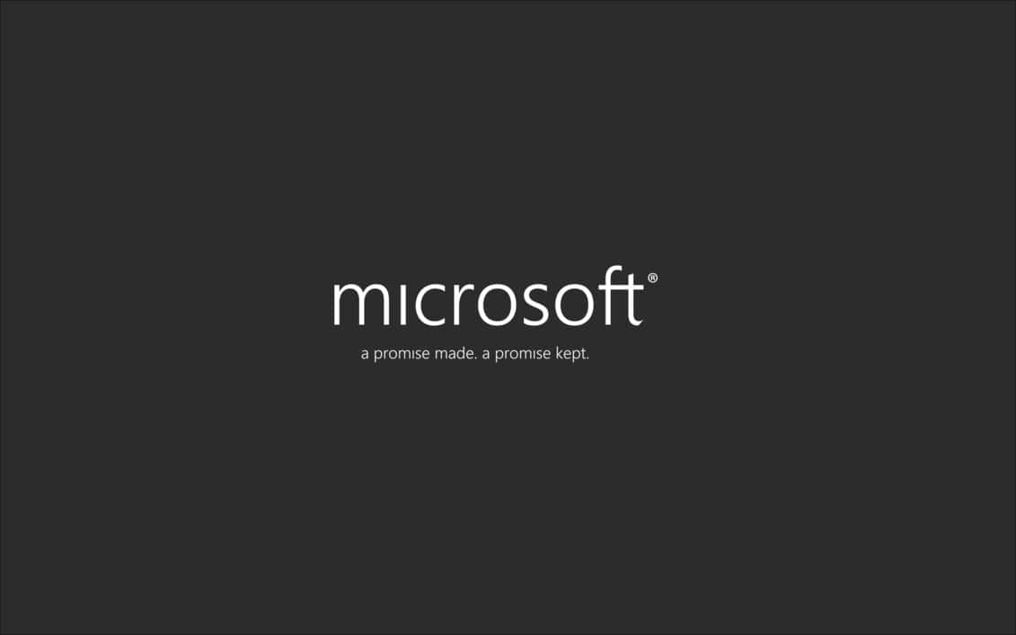  壁紙 — 極簡深灰色背景，中央放置白色Microsoft標誌和標語。