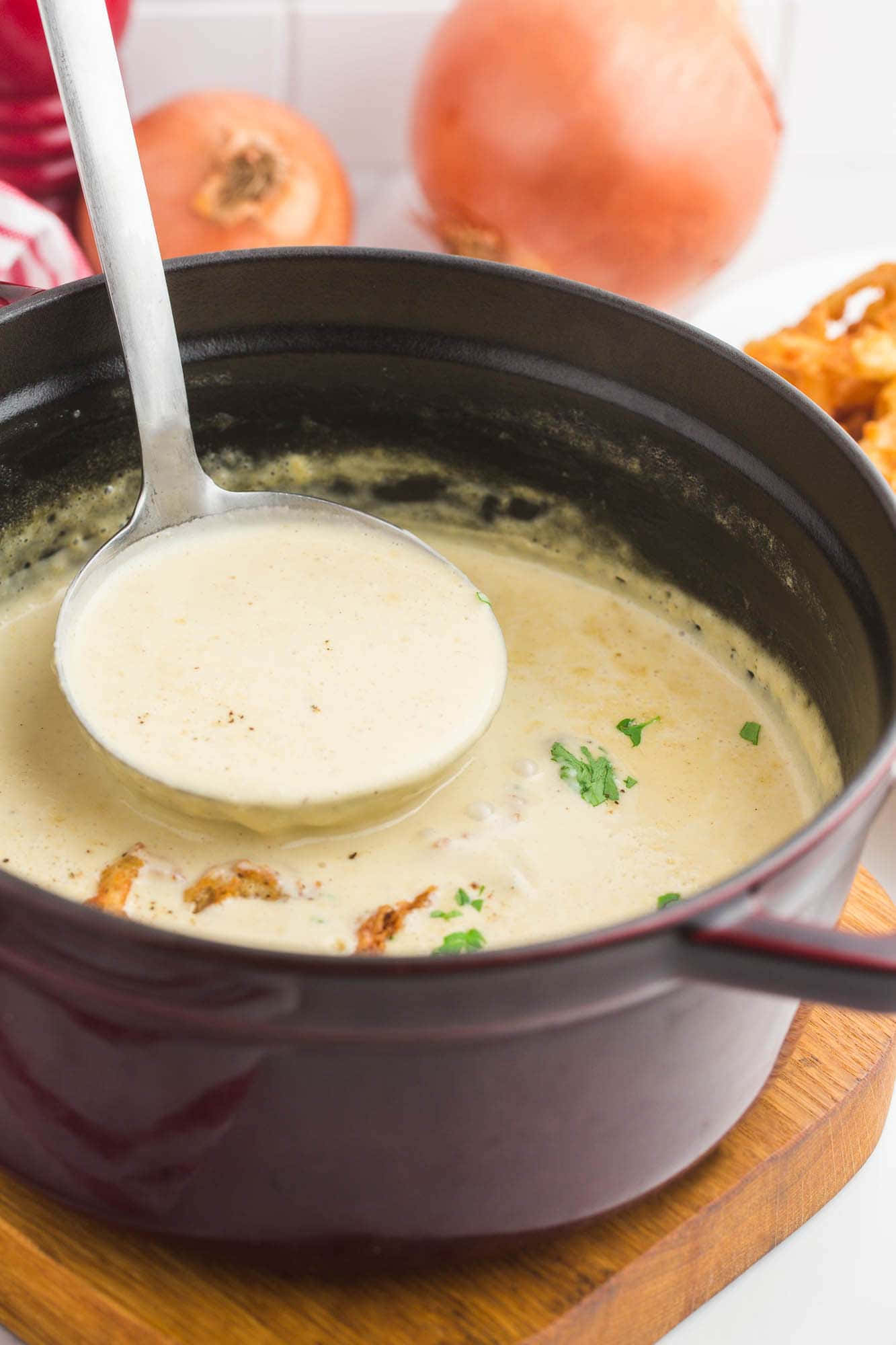 Soup 桌布 壁紙 — 湯勺從深色鍋中舀起忌廉洋蔥湯，放在木板上，飾以新鮮歐芹。