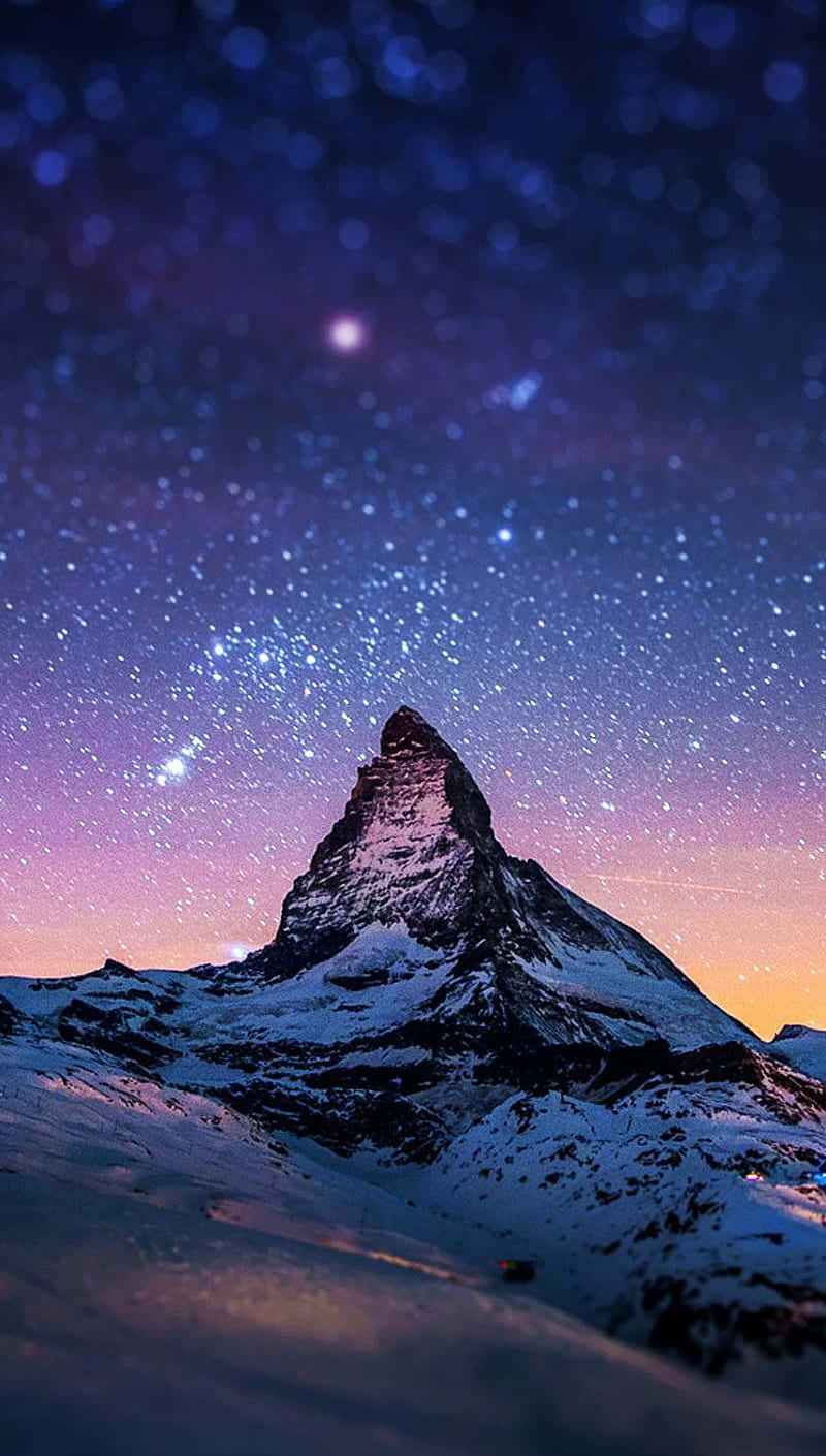  壁紙 — 積雪的馬特洪峰在充滿紫色和橙色色調的 vibrant 星空暮色天空下聳立。