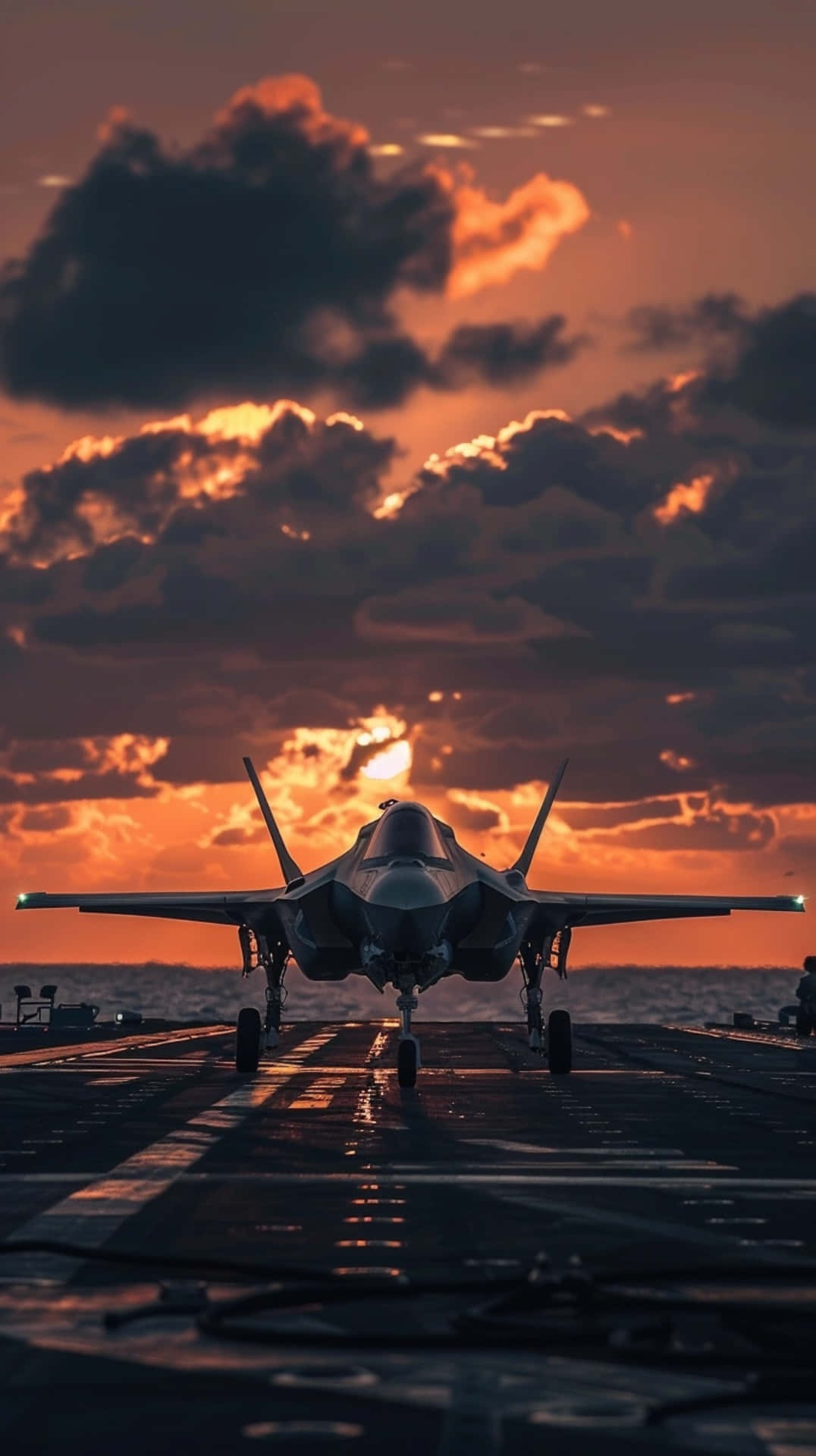  壁紙 — 一架戰鬥機在日落時分停在航空母艦甲板上，上方有火紅色的橙雲。