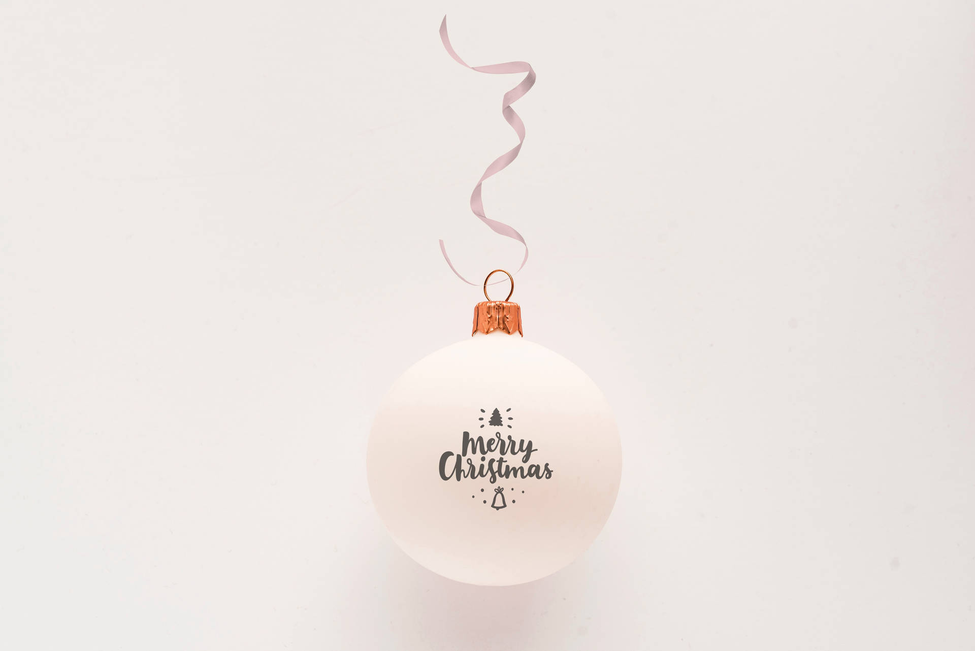 白色聖誕裝飾球 壁紙 — 一個簡約的白色聖誕裝飾，上面有「Merry Christmas」文字和小圖標，掛在純白色背景上。