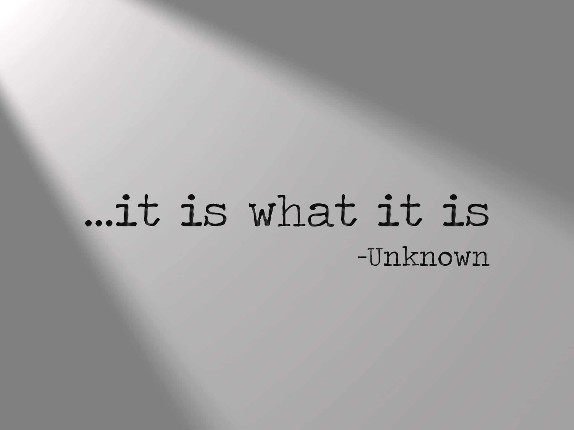  壁紙 — 簡約灰色牆壁，帶有對角陰影和居中引文 it is what it is，作者不詳。
