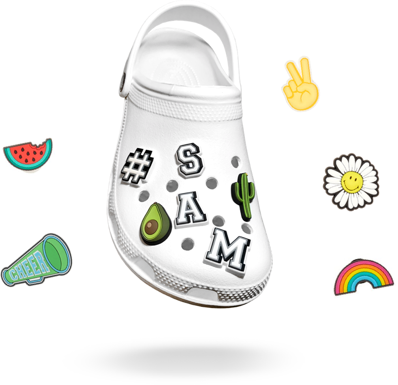 裝飾 Jibbitz 零件的白色 Croc 鞋 壁紙 — 一雙白色 Croc 木屐，裝飾著色彩繽紛的貼紙，包括牛油果、仙人掌、名字和歡呼符號，背景為黑色。