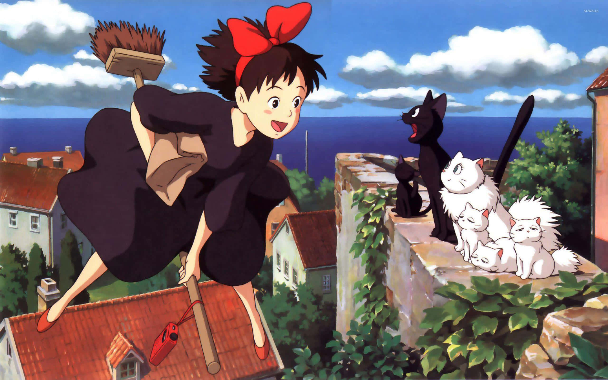 Jiji 坐在樹枝上俯瞰魔法世界 壁紙 — 一個開心的動漫女孩，戴著紅色蝴蝶結，拿著掃帚飛越屋頂，黑白貓咪從石牆上觀看。