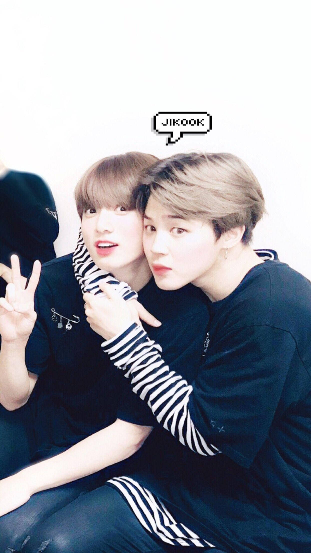 Jikook 與文字氣泡 壁紙 — 兩名身穿深色服裝的年輕男子在純白背景前緊密擺姿勢，一人比出和平手勢，另一人靠過來，帶有像素化對話框，寫著JIKOOK。
