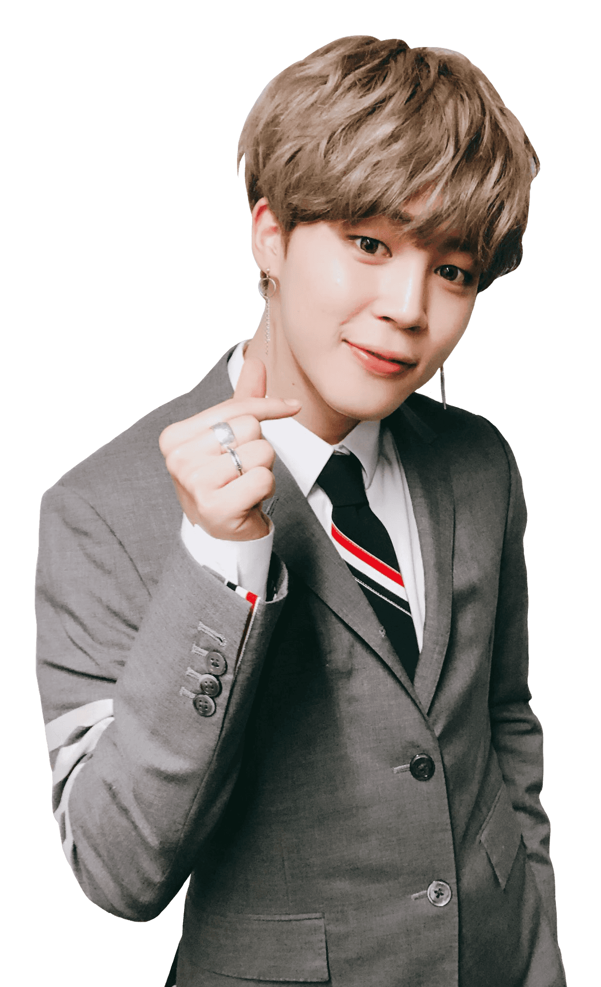 Jimin穿西裝微笑 壁紙 — 一位身穿灰色西裝、打著條紋領帶的年輕男子在黑色背景前微笑並指向相機。