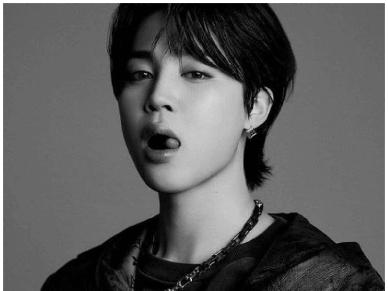 一個年輕男子留著短黑髮，戴著鏈條項鍊，在黑白工作室肖像中。 — Jimin GIF 壁紙