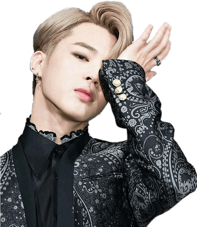 Jimin 身穿佩斯利黑衣造型 壁紙 — 一位時尚的年輕金髮男子，身穿黑色佩斯利夾克，在黑色背景前將一隻手靠近臉部擺姿勢。