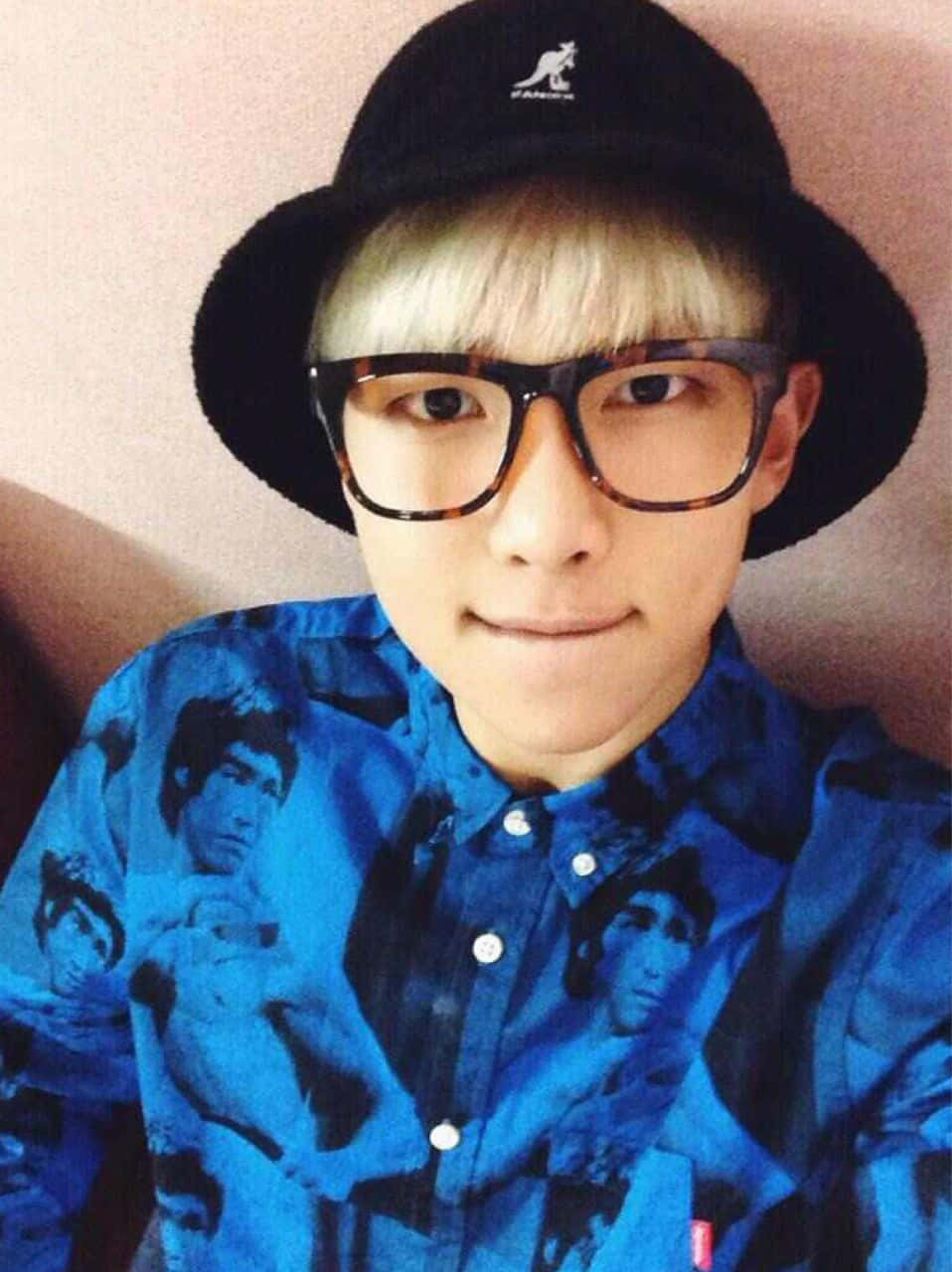 Bts Rap Monster 桌布 壁紙 — 一位金髮年輕男子戴著黑色漁夫帽和玳瑁眼鏡，在自拍中微笑。
