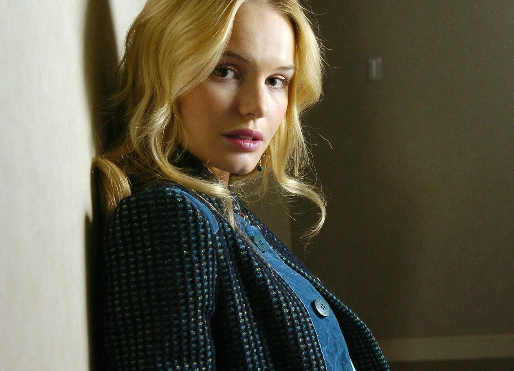 Kate Bosworth 桌布 壁紙 — 一位金髮波浪長髮的女性，身穿質感藍色外套和牛仔襯衫，靠著牆壁。