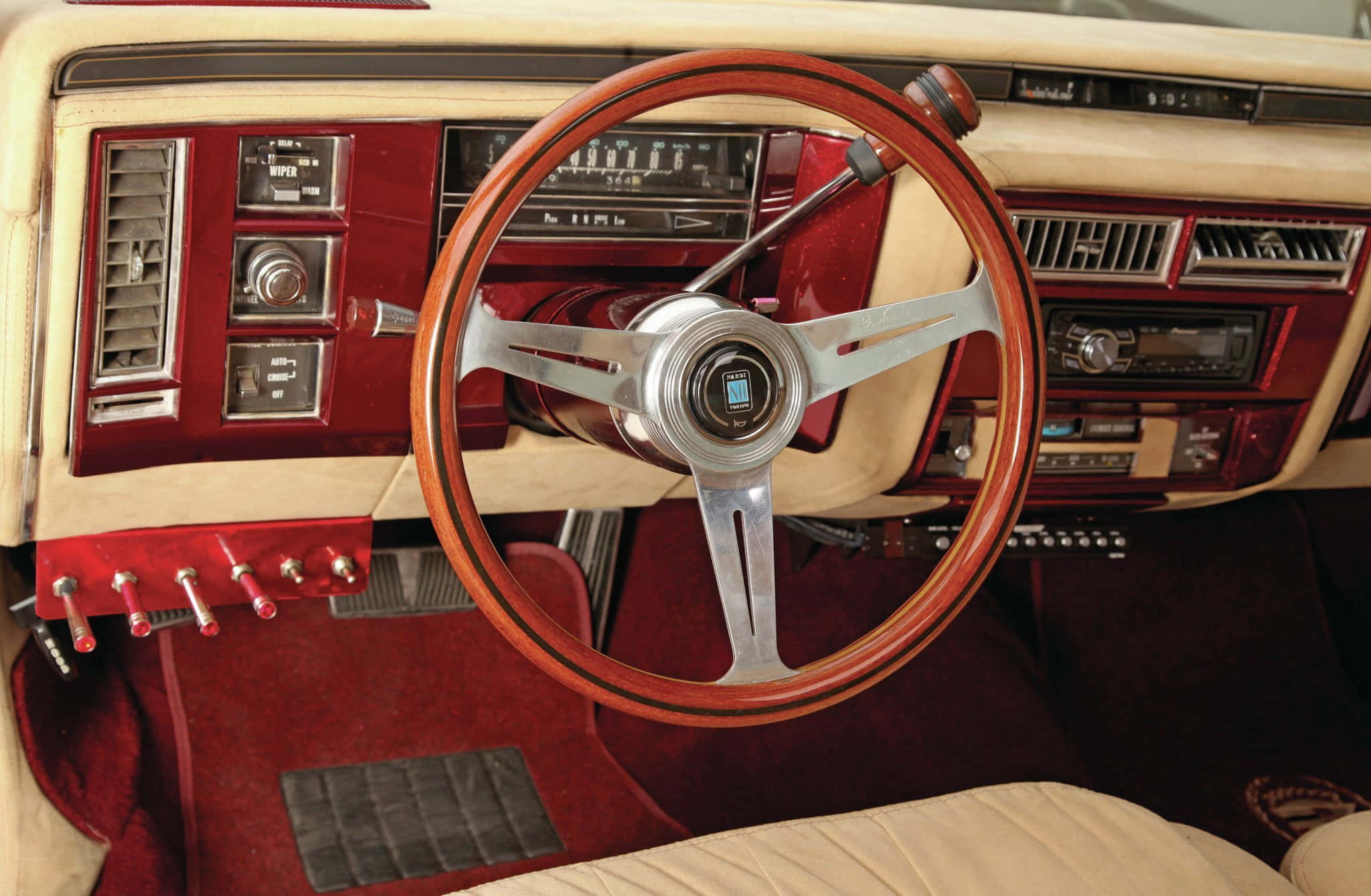 Cadillac Deville 桌布 壁紙 — 經典車豪華內飾特寫，配備木質方向盤和紅色皮革座椅。