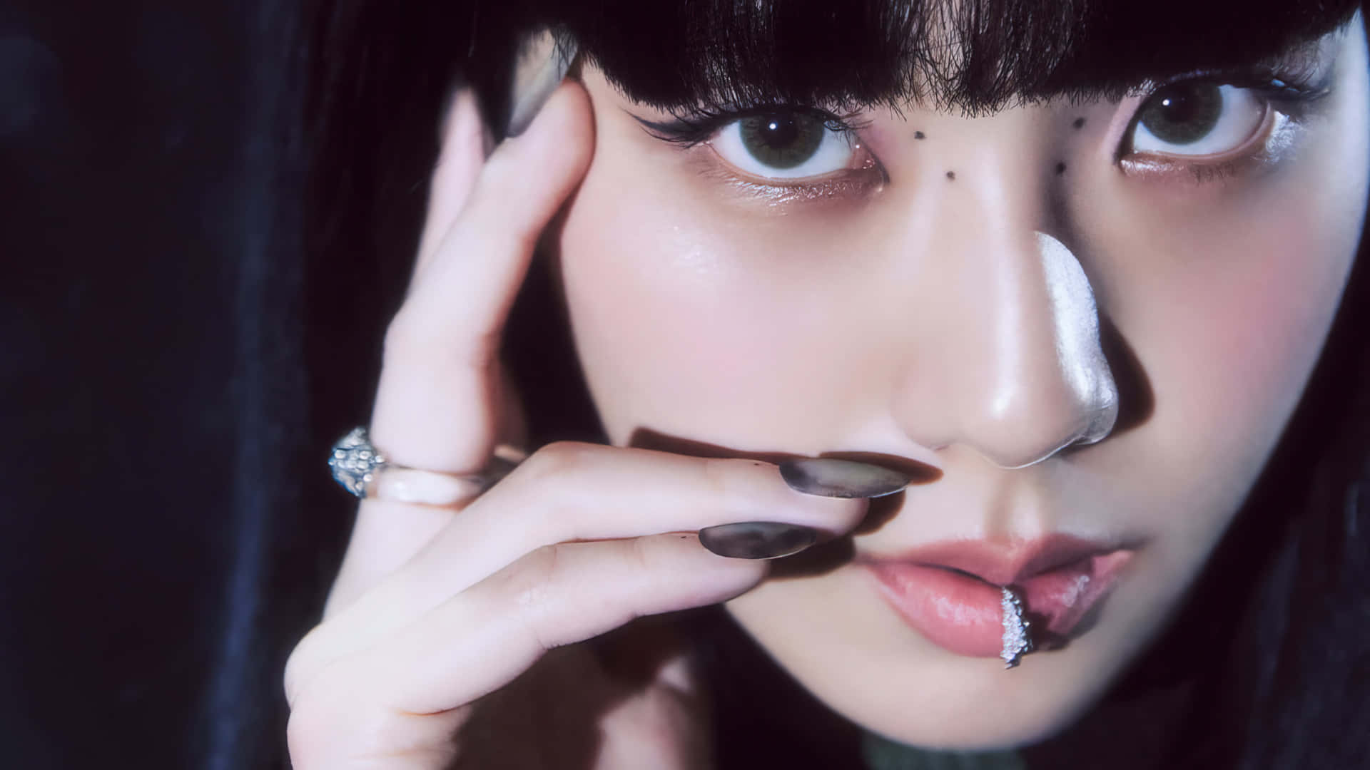 Jisoo BLACKPINK 時尚唇環魅力寫真 壁紙 — 特寫肖像，一位深色頭髮、妝容誇張的女性在昏暗燈光下將香煙靠近嘴唇。