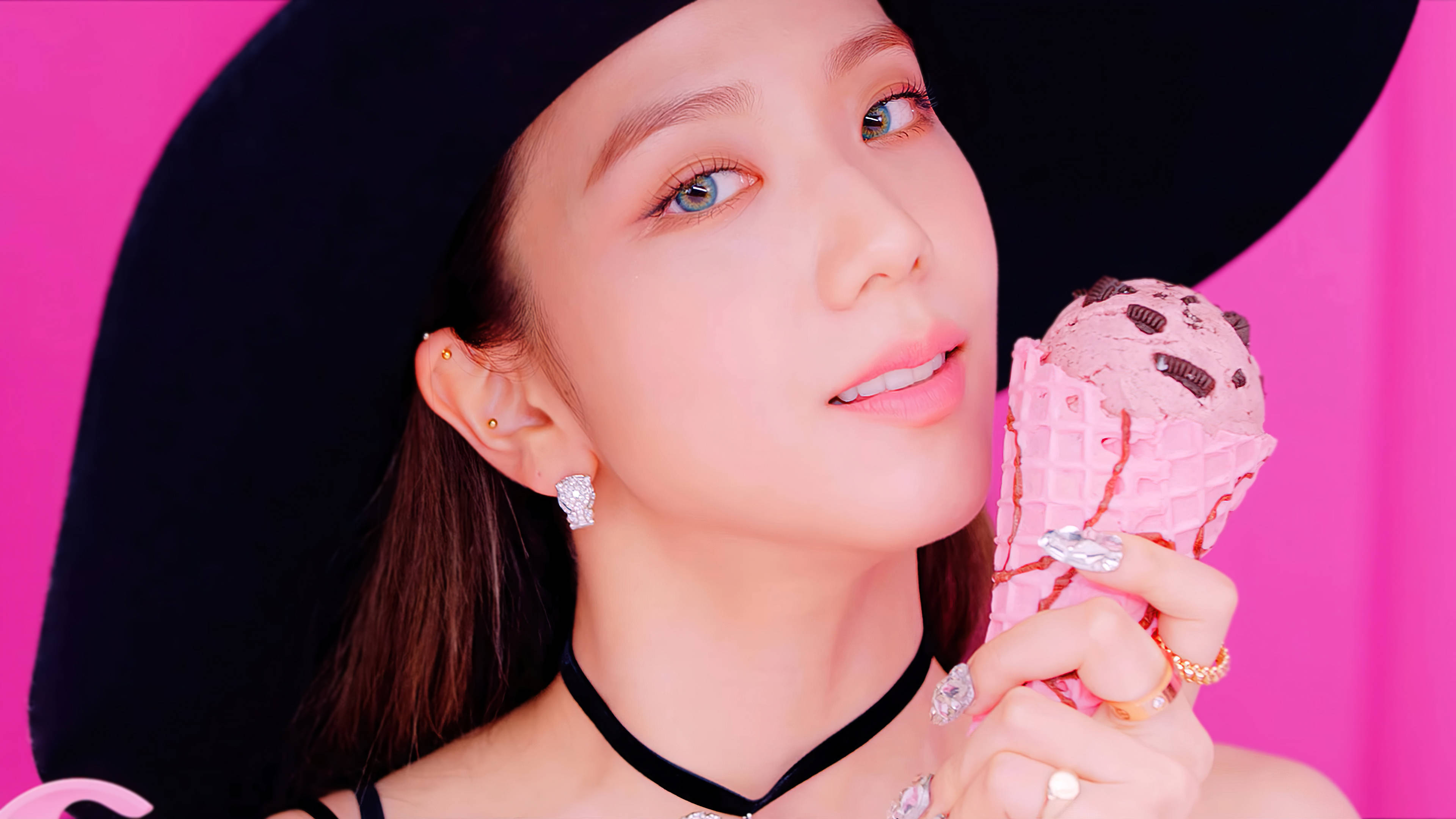 Jisoo 冰淇淋 壁紙 — 一位戴黑色帽子的女士在充滿活力的粉紅色背景前拿著粉紅色雪糕筒。