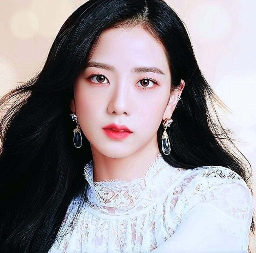 年輕黑長髮女性身穿白色蕾絲上衣和水晶耳環。