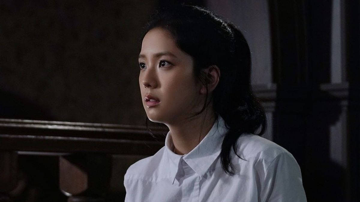 Jisoo 飾演《雪滴花》中的 Eun Yeong-ro 壁紙 — 一位身穿白恤衫的年輕女性，在光線昏暗、有木欄杆的房間裡睜大眼睛向上凝視。