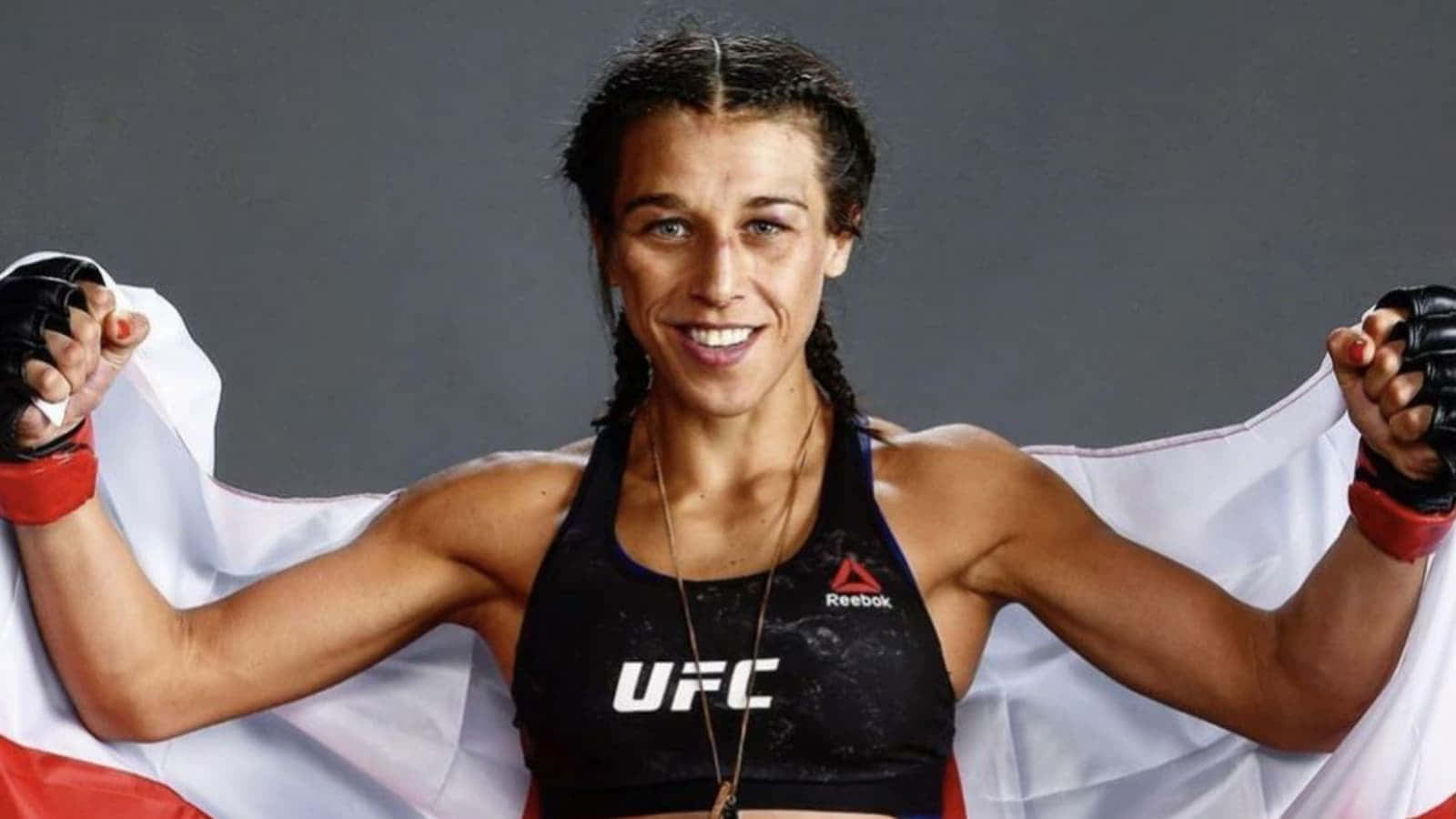 女性UFC拳手持波蘭國旗，露出勝利的笑容。