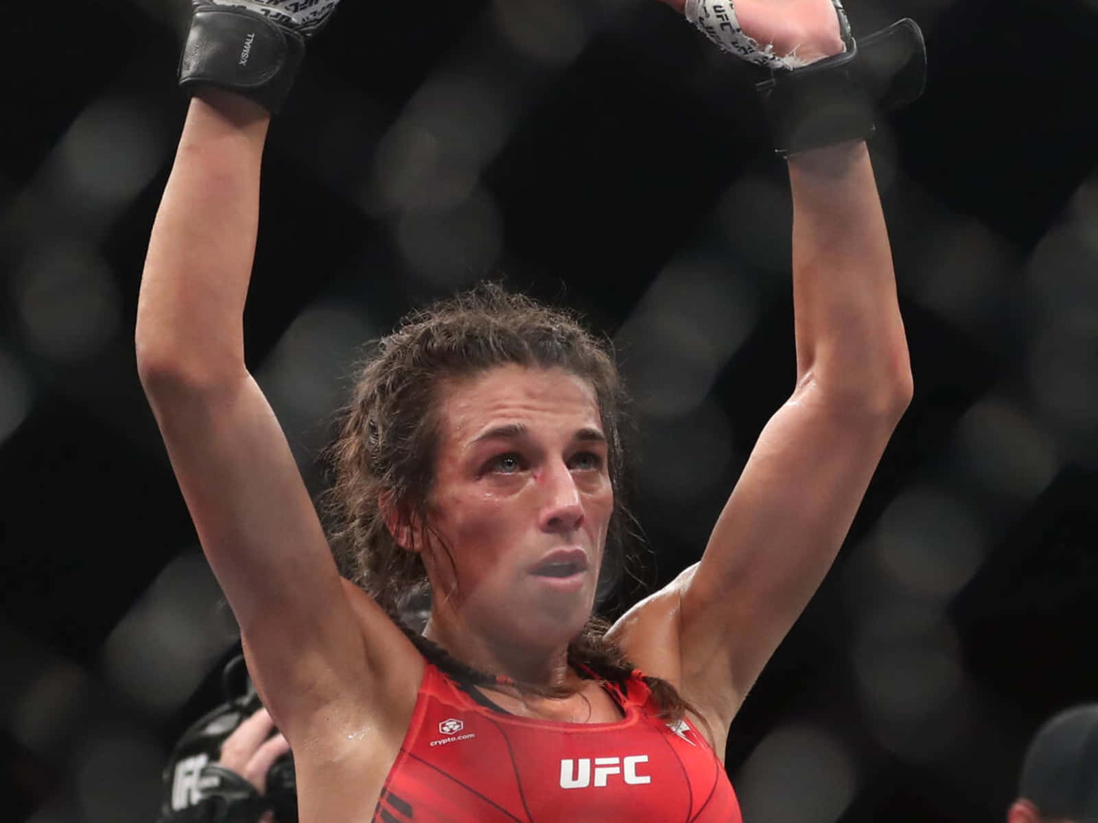 女性MMA拳手在UFC八角籠中舉拳慶祝勝利。
