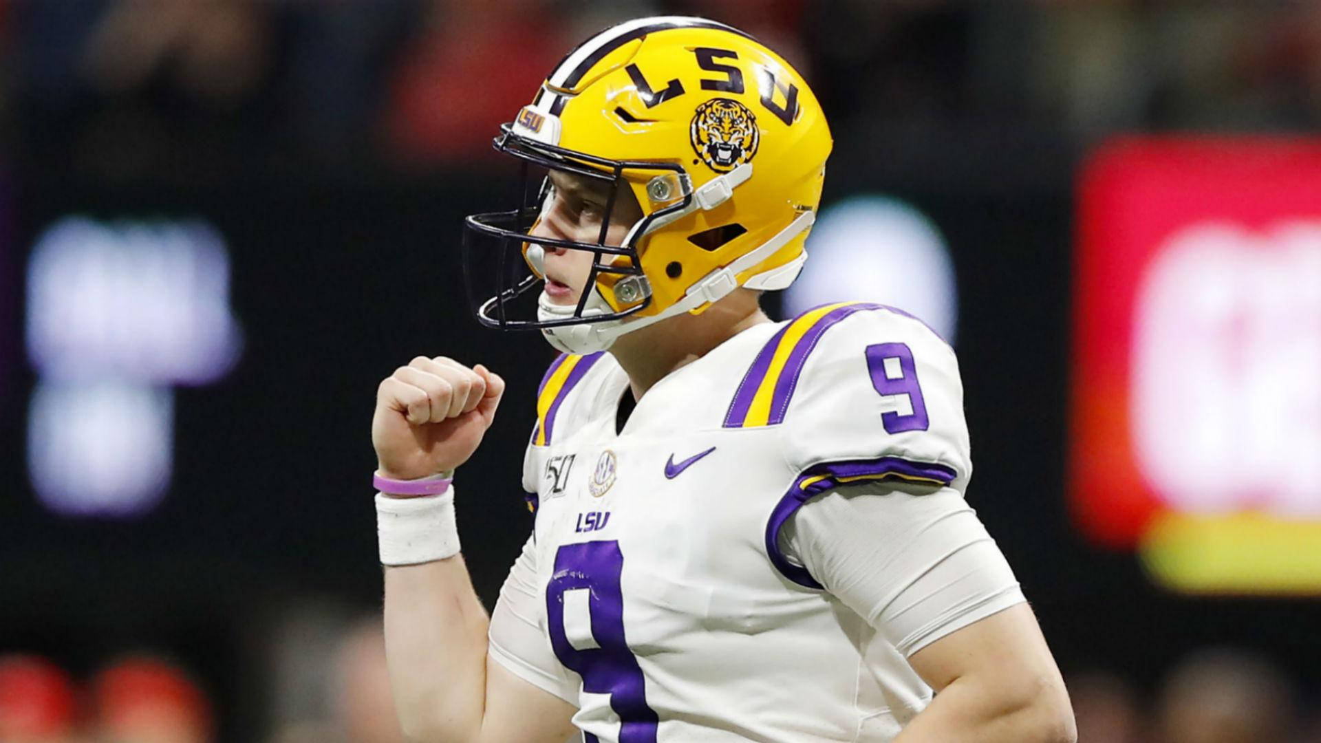 Joe Burrow 成功姿勢 壁紙 — 一名LSU足球員戴著黃色頭盔、身穿白色9號球衣，在夜間比賽中握拳慶祝勝利。