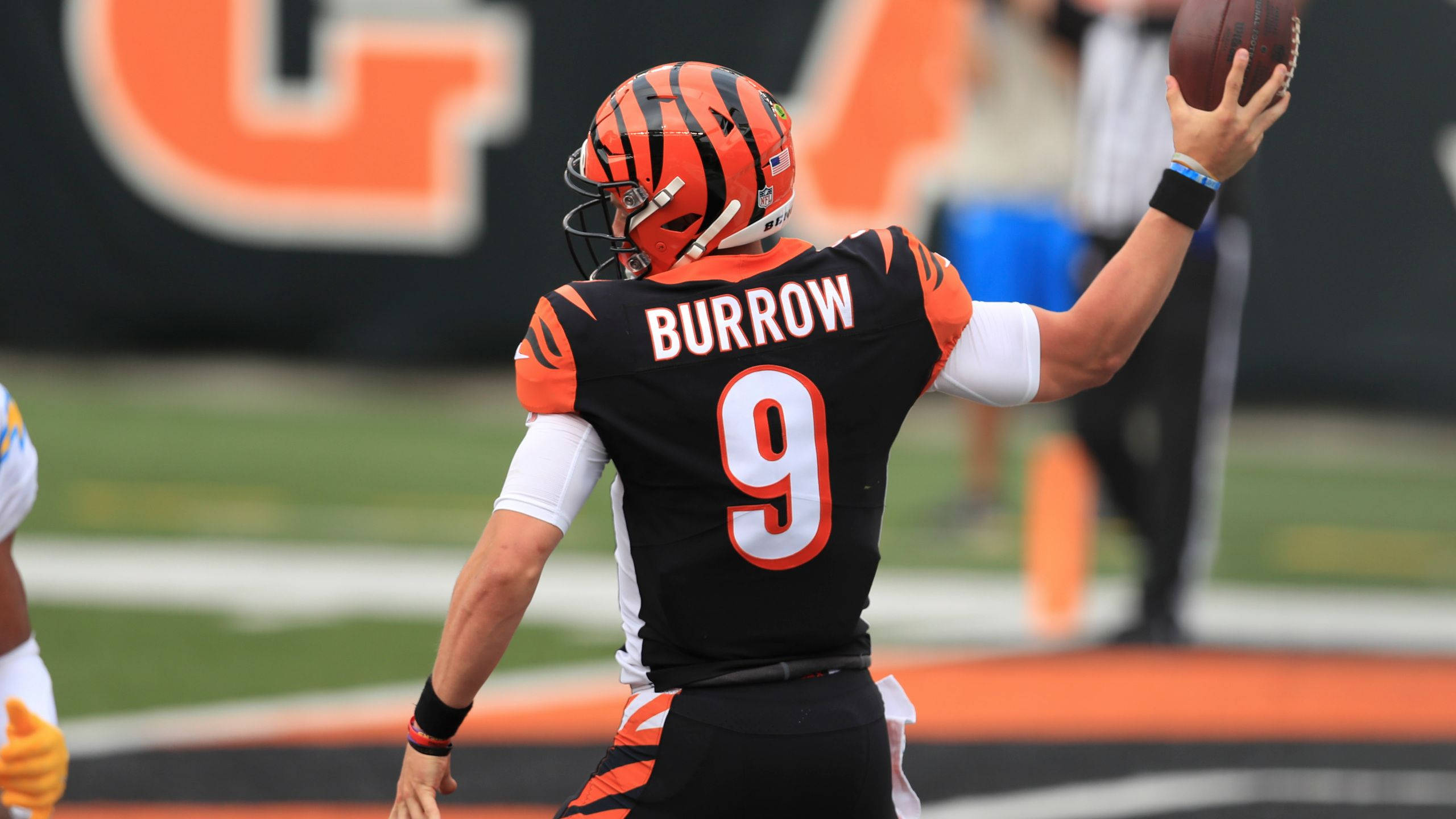 Joe Burrow 擲球蓄力 壁紙 — 身穿孟加拉虎隊球衣的四分衛Burrow在日間比賽中準備擲出美式足球。