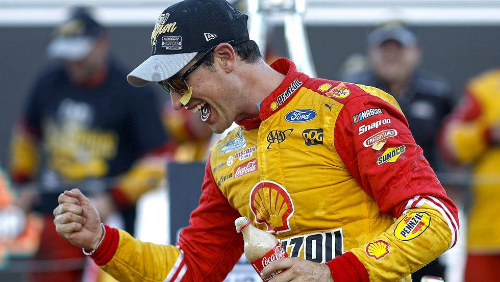 NASCAR車手握緊拳頭並手持可口可樂瓶慶祝勝利。
