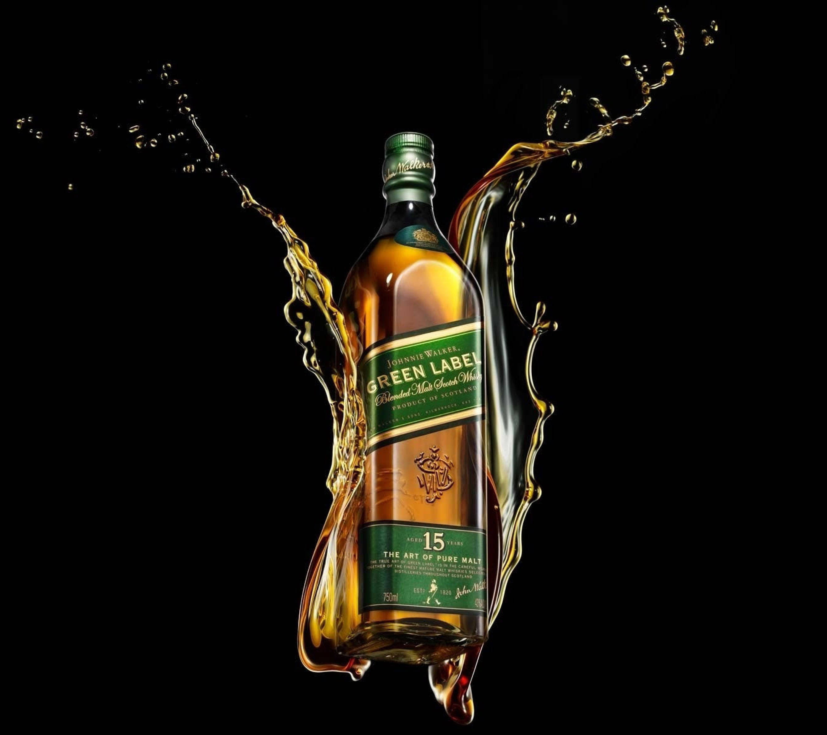 Johnnie Walker Green Label數位渲染 壁紙 — 一瓶尊尼獲加綠牌威士忌，在純黑背景上被動態的金色液體飛濺所環繞。