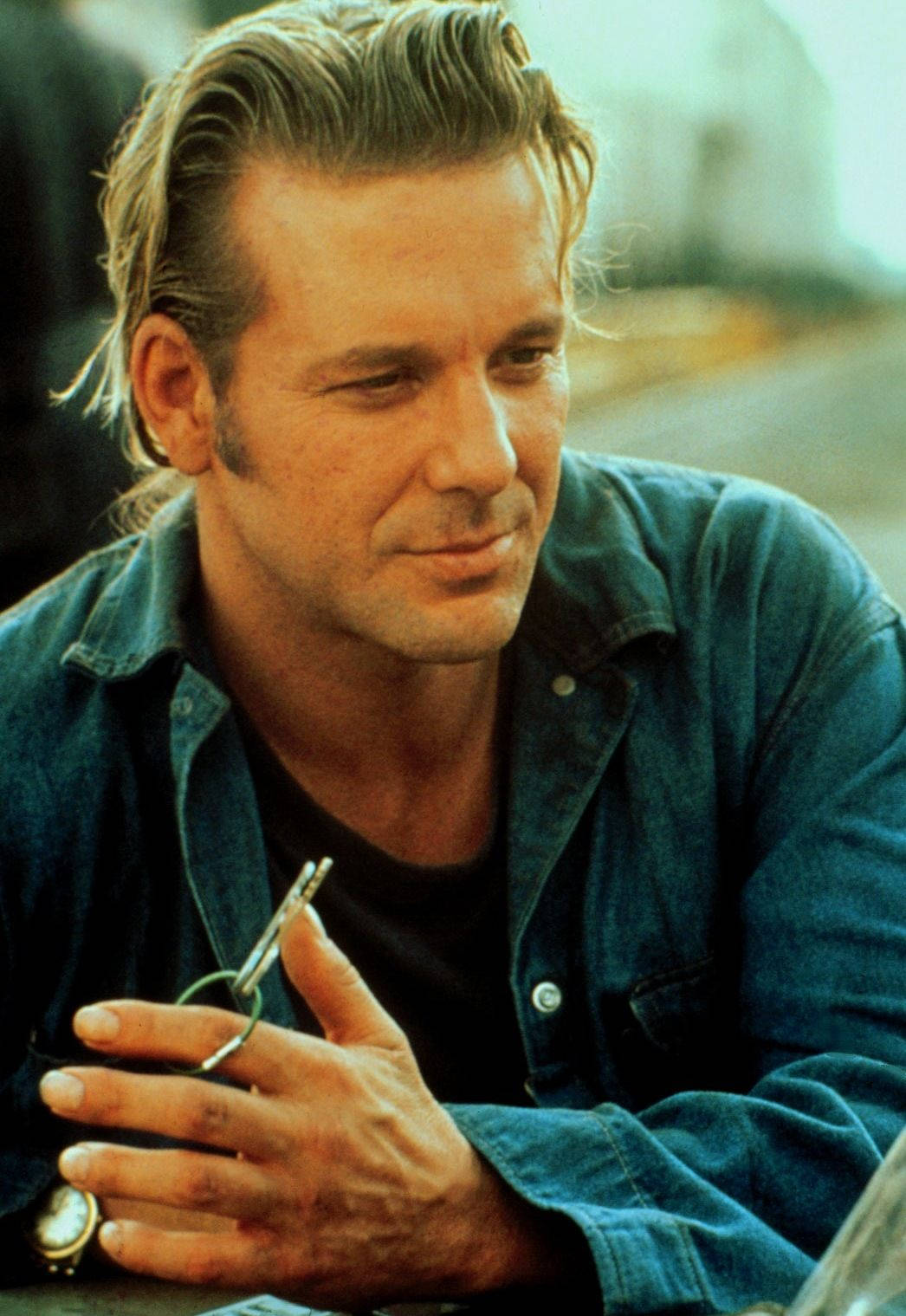 米基·洛克在電影《Johnny Handsome》中飾演John Sedley 壁紙 — 一個頭髮造型時尚、身穿牛仔襯衫的男人，若有所思地凝視著，手裡拿著一支煙。