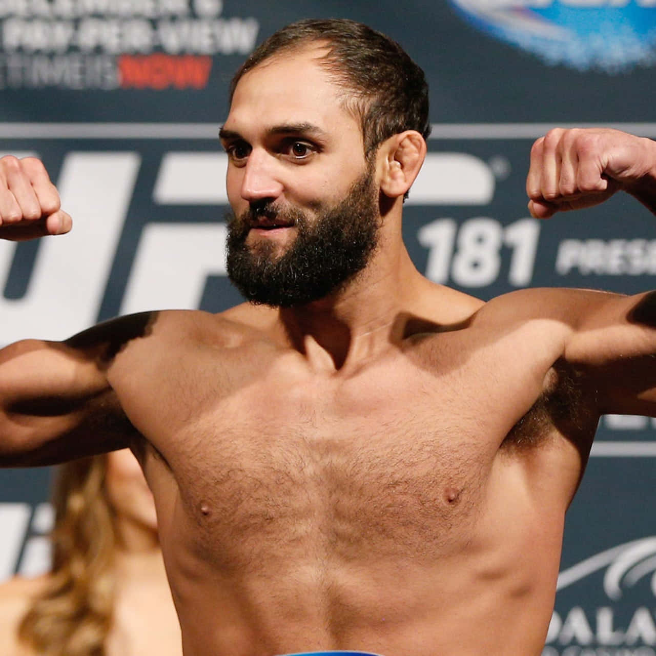 赤裸上身的拳手在 UFC 稱重活動中彎曲手臂。