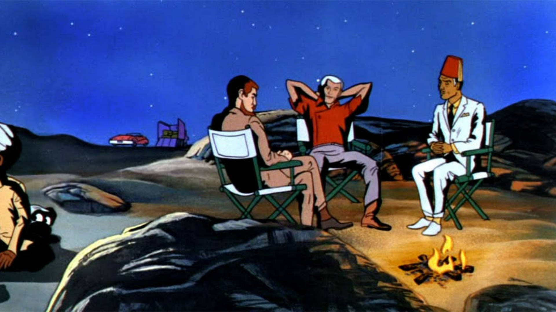 三人在沙漠夜晚的星空下圍坐在營火旁。