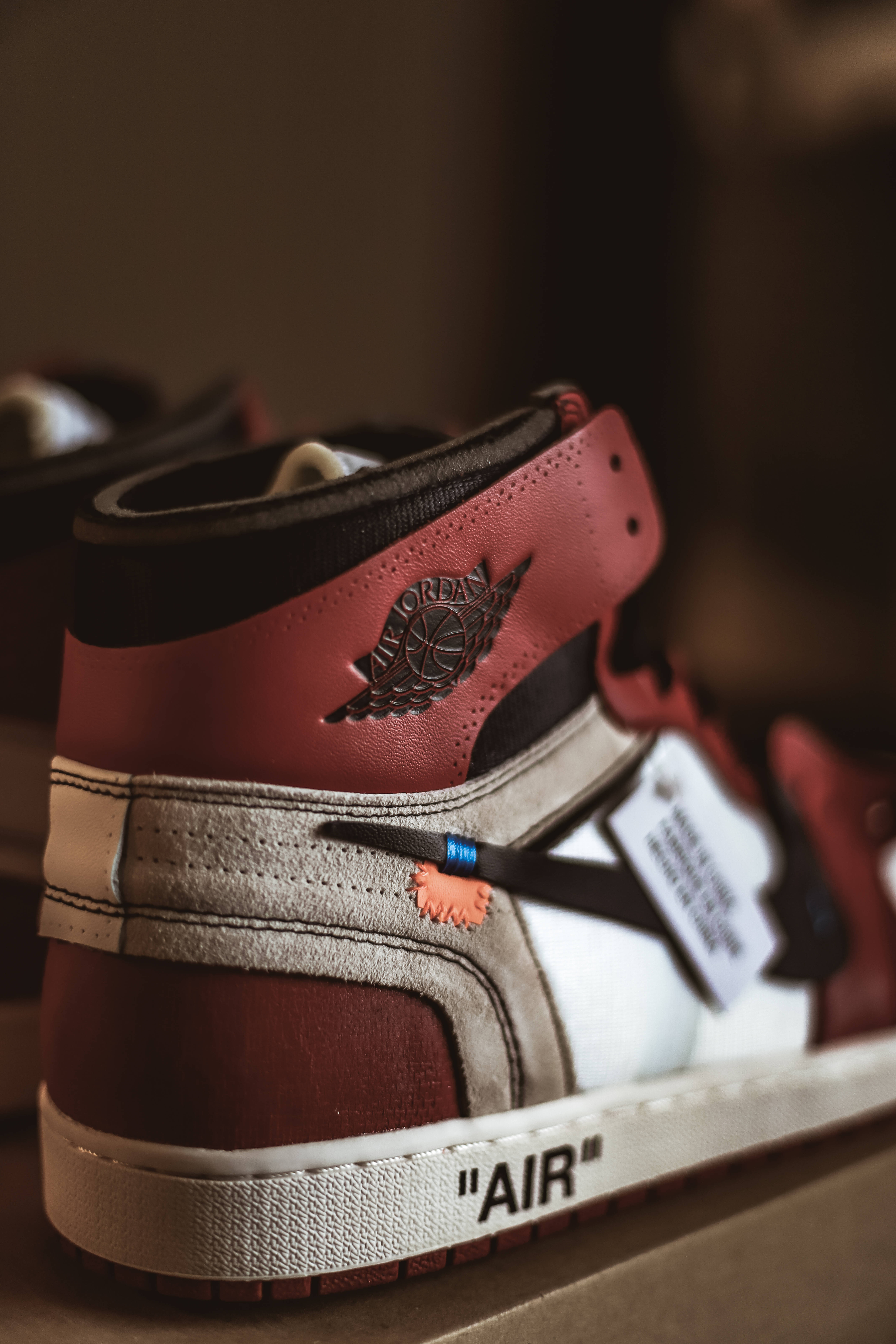 以一雙新鮮的 Jordan 鞋履，讓你的造型更出眾 壁紙 — 紅色、白色和黑色高筒運動鞋的特寫，帶有可見的品牌和標籤細節。