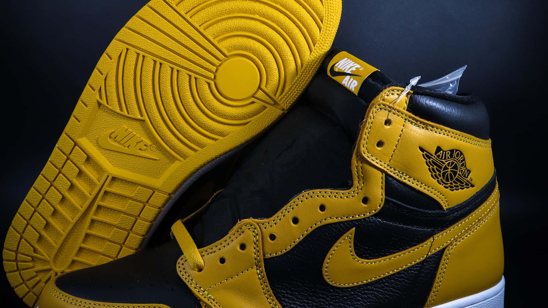 黑色和金色Air Jordan 1運動鞋，鞋底抬起，在深色背景下。
