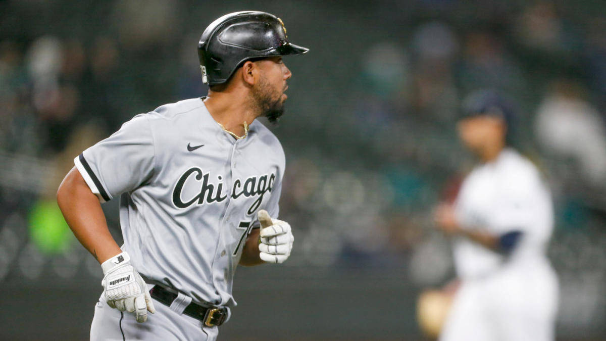 Jose Abreu 奔跑 壁紙 — 一位芝加哥棒球運動員穿著灰色制服，在夜間比賽中於球場燈光下專注地奔跑。