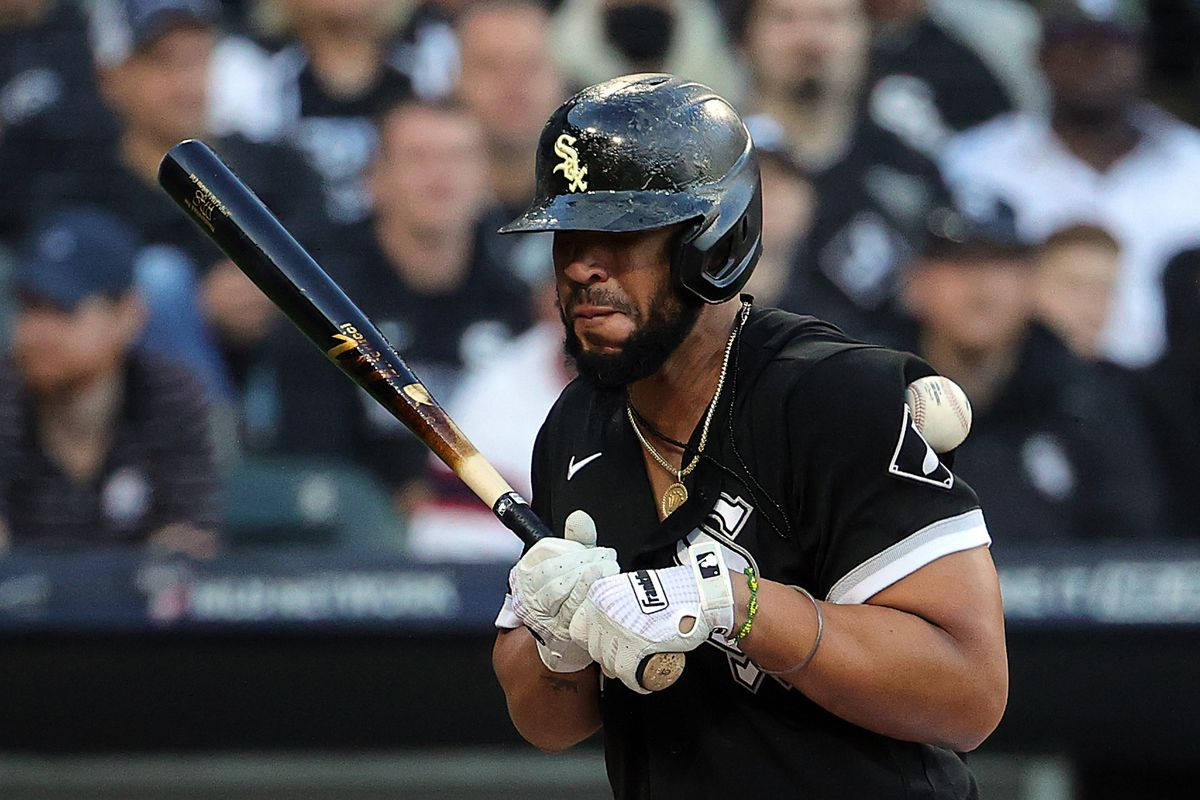 Jose Abreu 打擊白球照 壁紙 — 一名身穿黑色球衣的棒球手在夜間比賽中，在球場燈光下，專注地握著球棒揮擊中段。