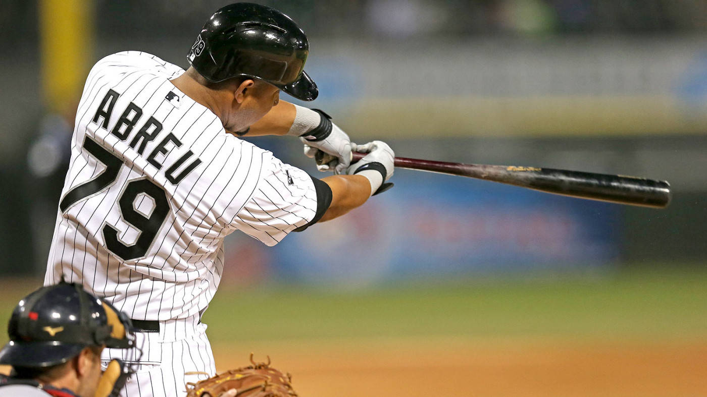 Jose Abreu 擊球 壁紙 — 身穿細條紋球衣的棒球手Abreu 79號在夜間比賽中揮棒，捕手在前景。