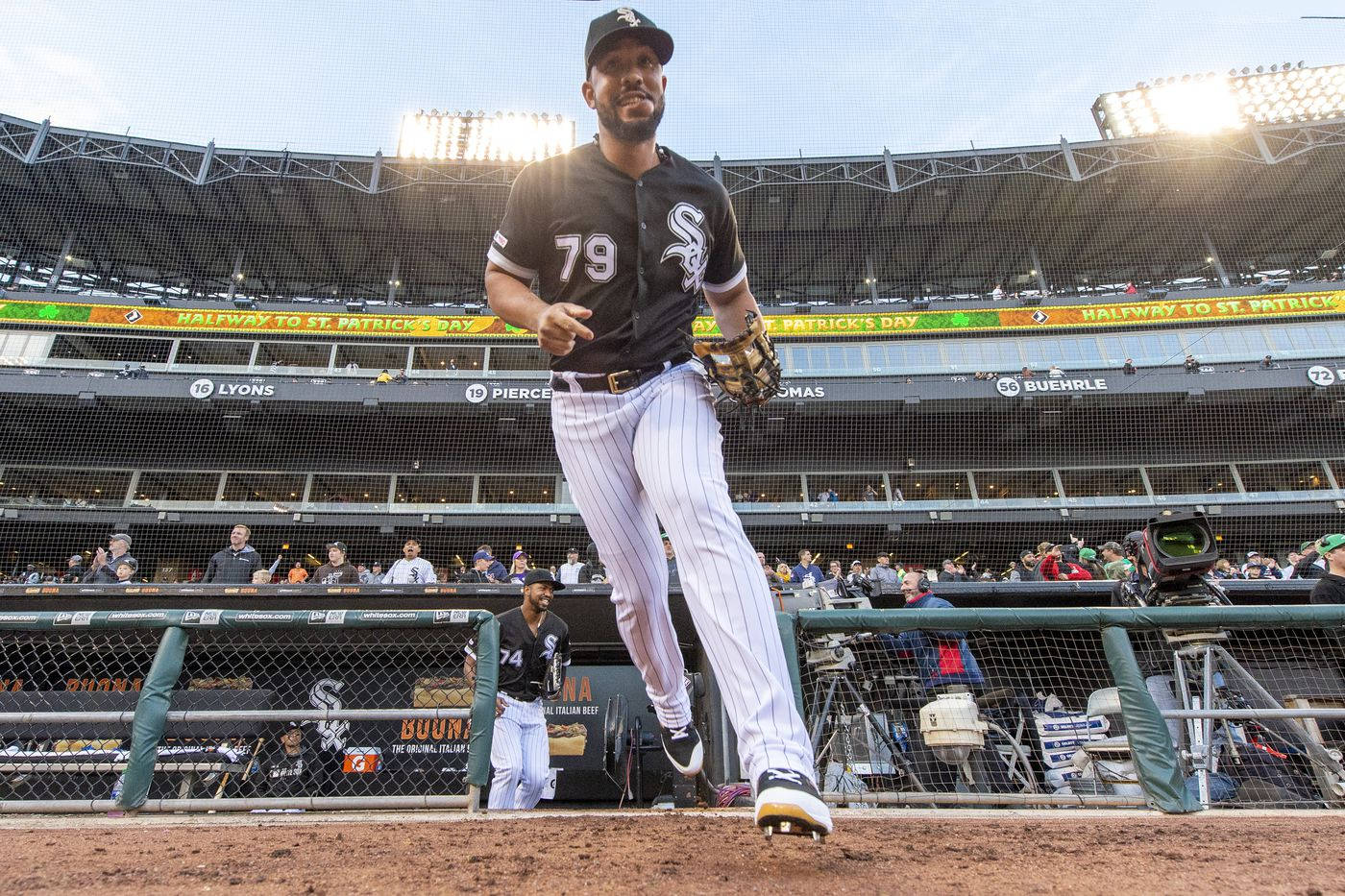 Jose Abreu 球場照 壁紙 — 一名身穿芝加哥白襪隊球衣的棒球選手在陽光明媚的球場上投球，背景有體育館看台和球迷。