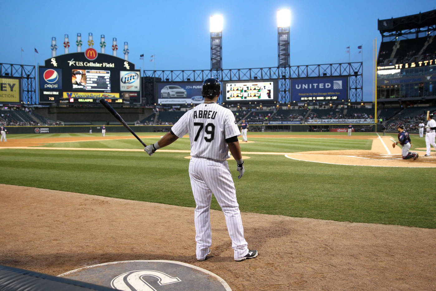 Jose Abreu 站姿 壁紙 — 一名身穿79號球衣的棒球運動員在黃昏的球場燈光下站在本壘板，手持球棒。