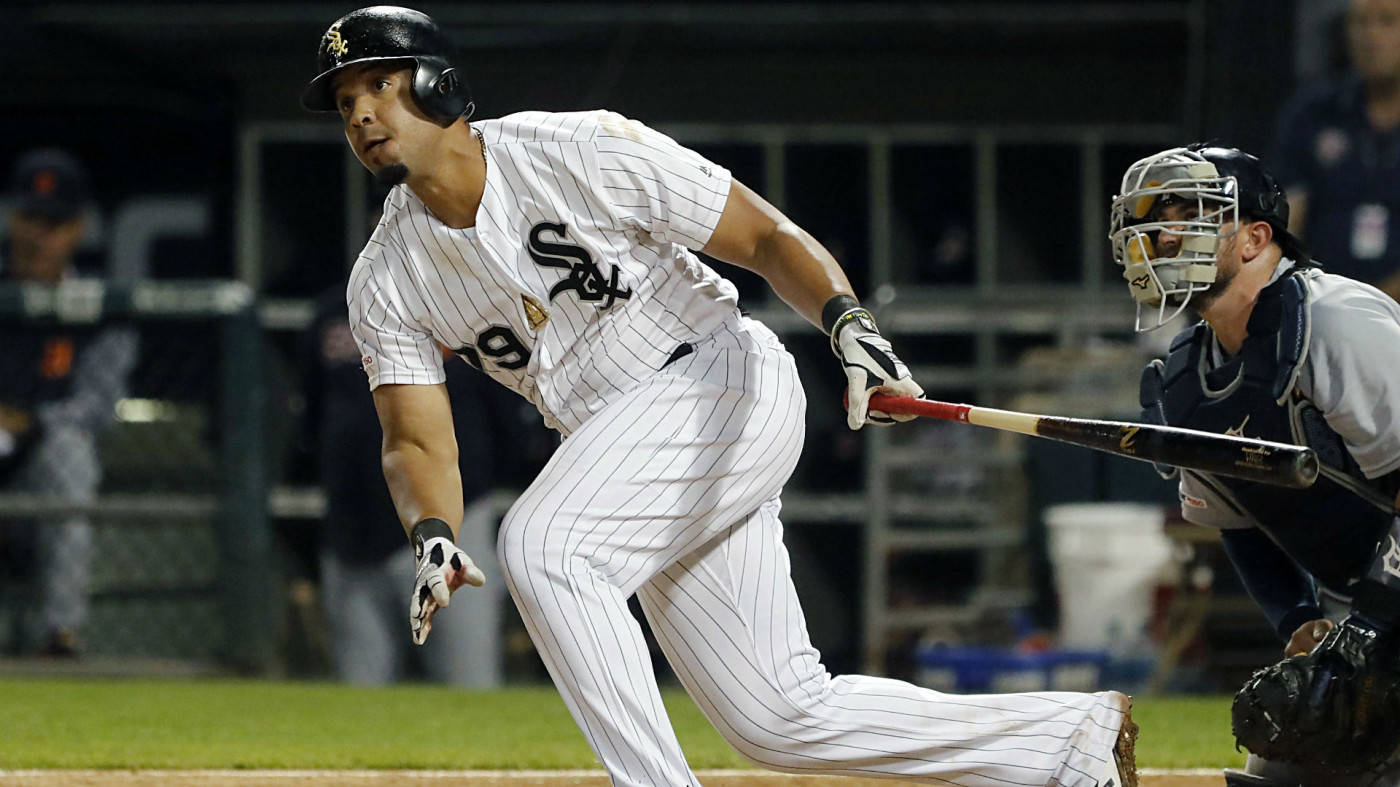 Jose Abreu 跑步 壁紙 — 一名身穿白色細條紋球衣的棒球手在夜間比賽中，在捕手蹲在他身後的情況下，專注地揮棒。