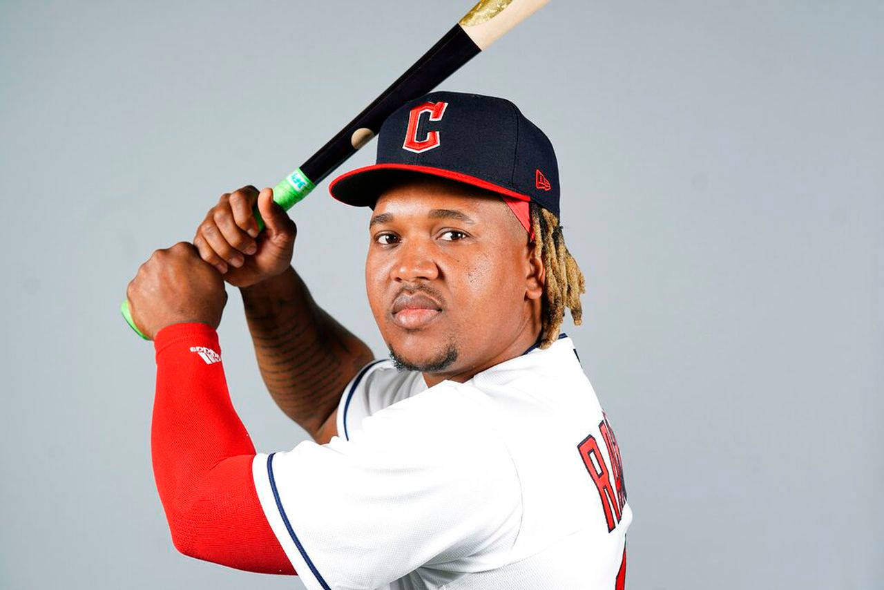 Jose Ramirez 棒球寫真 壁紙 — 一名身穿克里夫蘭球衣的棒球運動員，在純灰色背景前將球棒扛在肩上。
