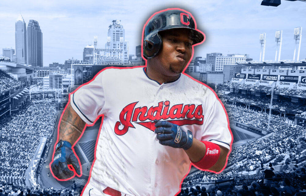 Jose Ramirez 球場藝術 壁紙 — 一名身穿克里夫蘭印地安人隊球衣的棒球選手，在擠滿觀眾的體育場中奔跑，背景是城市天際線。