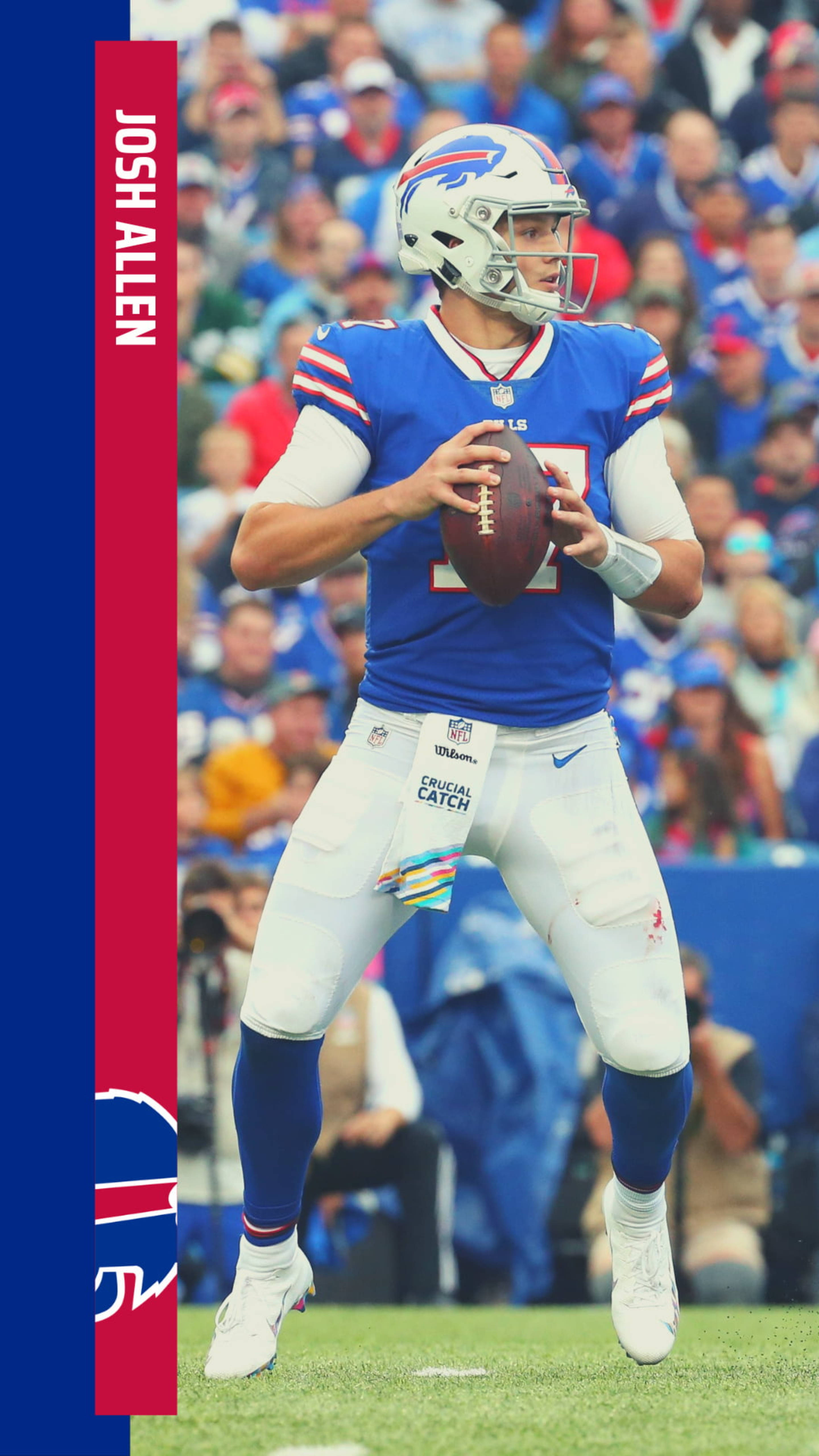 Josh Allen Buffalo Bills 球員肖像 壁紙 — 四分衛 Josh Allen 身穿藍白 Buffalo Bills 球衣，在比賽中準備擲出橄欖球，背景有模糊的球迷。