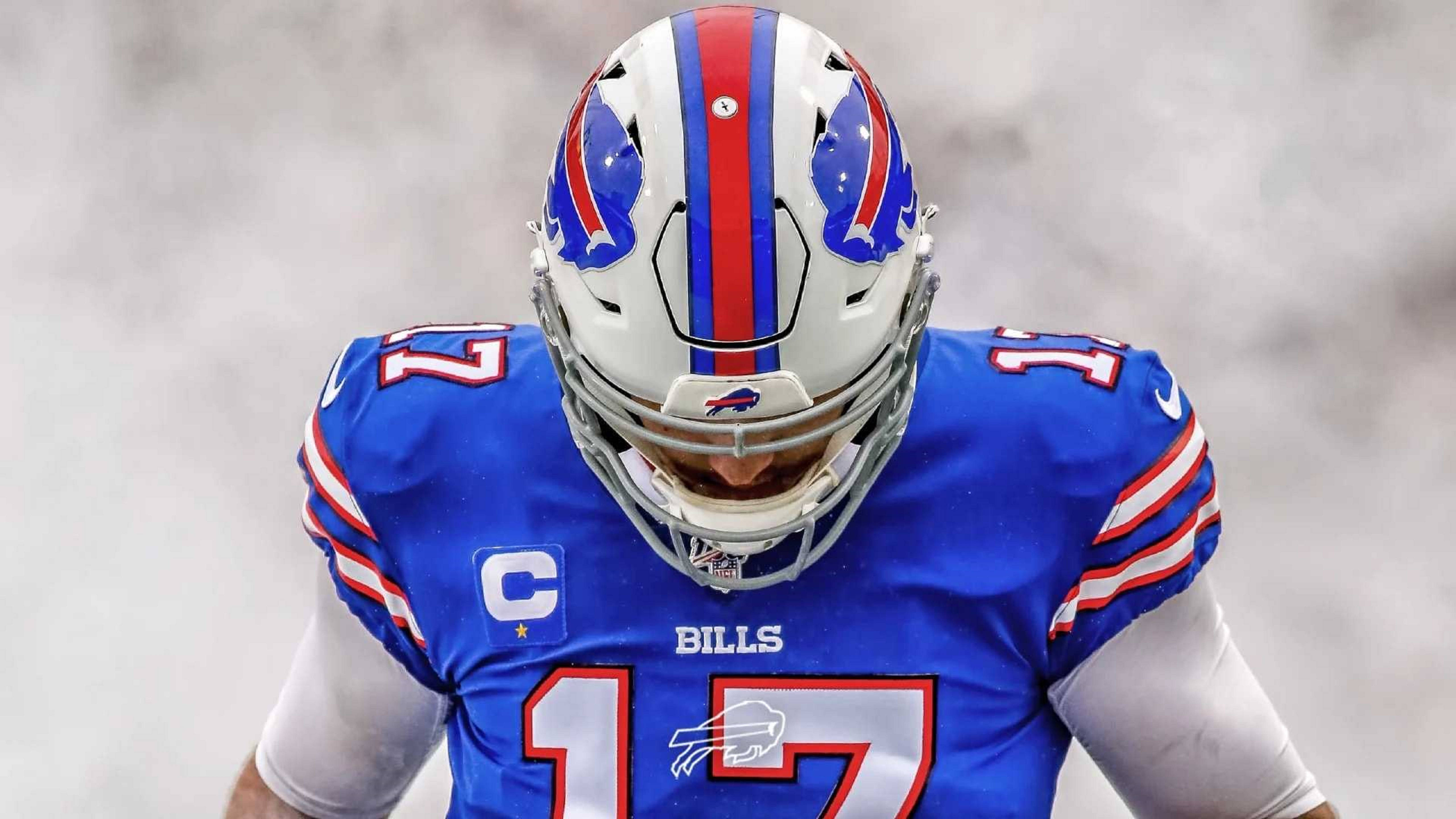 Josh Allen Buffalo Bills 四分衛肖像 壁紙 — 一位水牛城比爾隊的美式足球員，身穿藍色球衣，號碼17，帶有隊長C標誌，在迷霧的球場空氣中低頭站立。