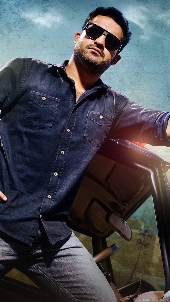 Jr Ntr 靠著車門快照 壁紙 — 一名戴著太陽眼鏡和牛仔襯衫的男子在明亮的天空下自信地靠在一輛車上。