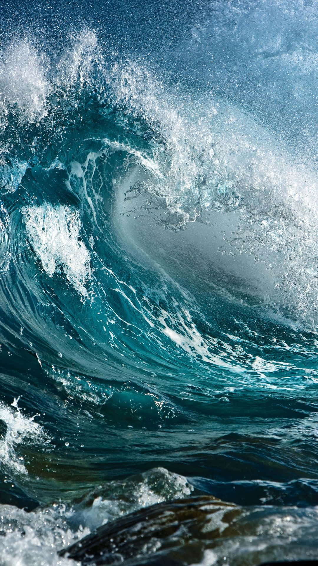 waves 桌布 壁紙 — 巨大的藍綠色海浪捲成完美的筒狀，帶著泡沫般的白色浪花，映襯著清澈的藍天。