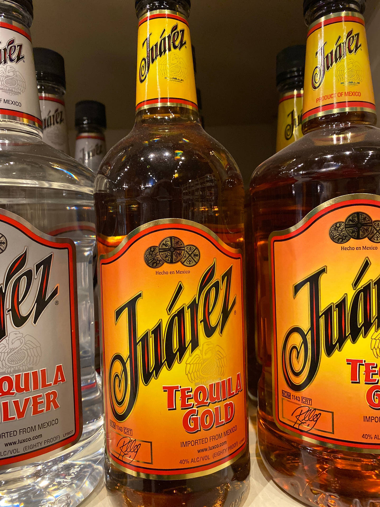 Juárez 龍舌蘭酒瓶以透明和金色品種陳列在商店貨架上。